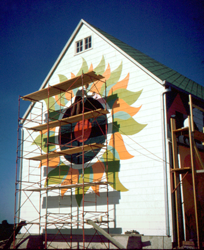 Frank Boggs painting the sunburst on the side of the barn.